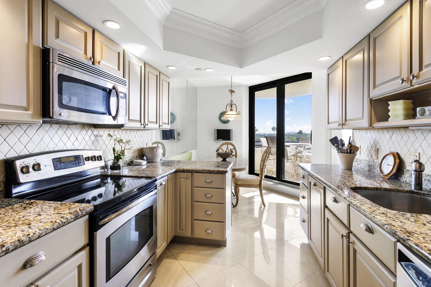 3322 Casseekey Island Road, Unit 504 Jupiter, FL 33477 - Photo 12 of 46 a kitchen with stainless steel appliances granite countertop a stove a sink and a microwave