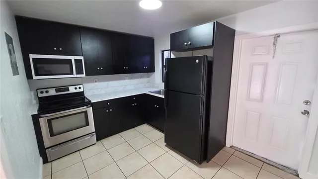 a kitchen with stainless steel appliances granite countertop a refrigerator and a stove top oven
