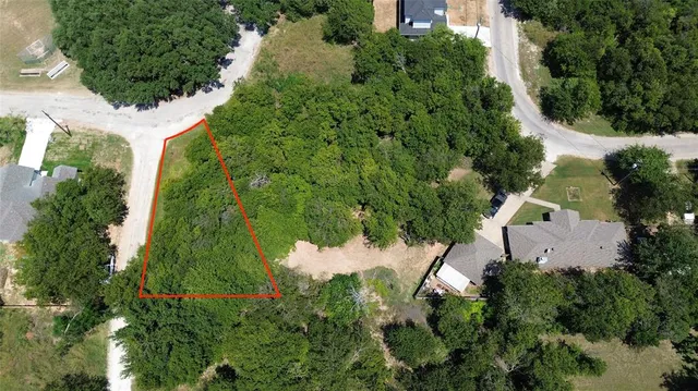 an aerial view of residential house with outdoor space and trees all around