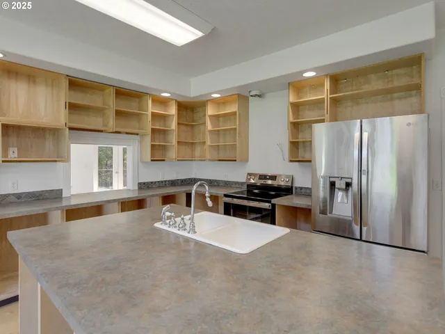 a kitchen with stainless steel appliances granite countertop a sink refrigerator and cabinets