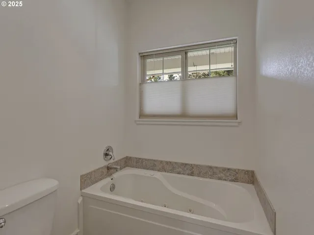 a white bath tub sitting next to a toilet