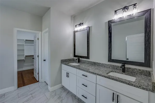 a bathroom with double sink and a mirror