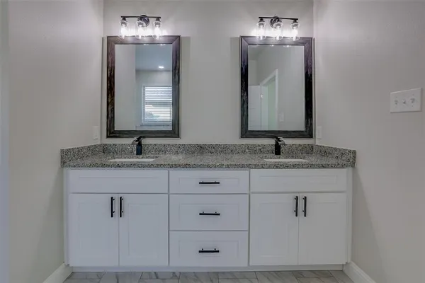 a bathroom with a sink vanity and mirror