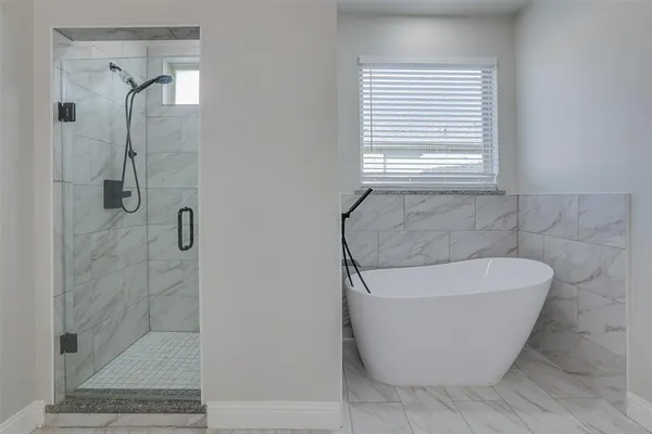 a white bath tub sitting in a bathroom next to a window