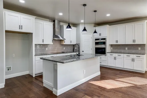 a large kitchen with stainless steel appliances granite countertop a stove a sink and a refrigerator
