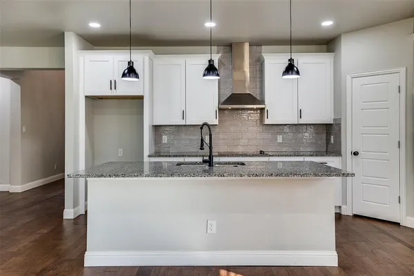 a view of a kitchen with kitchen island a sink stainless steel appliances and cabinets