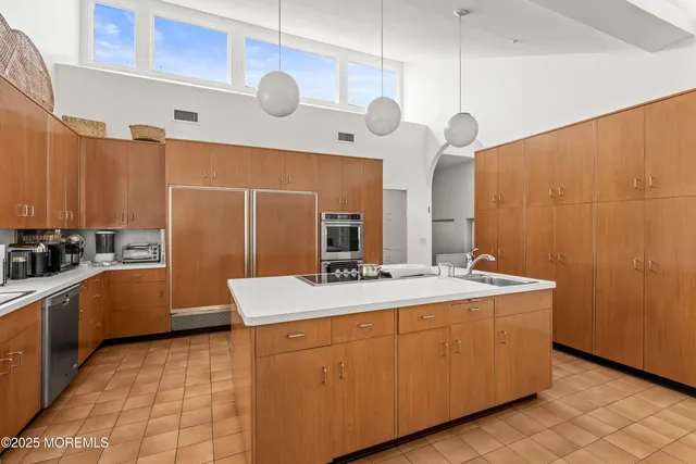 a kitchen with a sink a stove top oven and cabinets