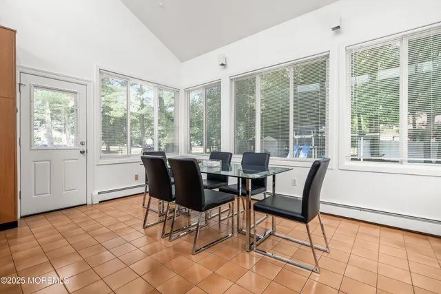 a dining room with furniture and large windows