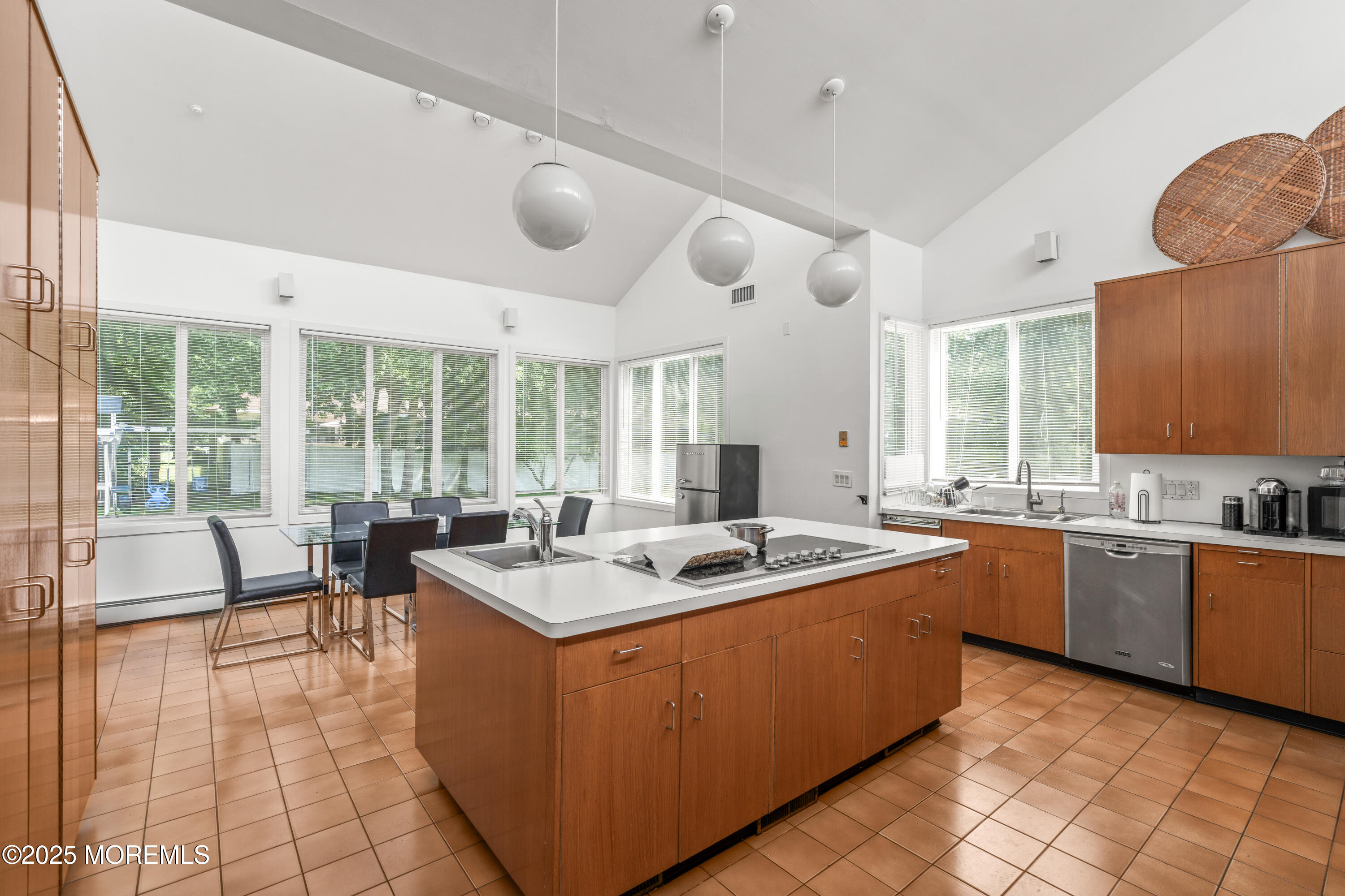 460 Runyan Avenue Deal, NJ 07723 - Photo 10 of 30 a kitchen with a stove a sink a dining table and chairs next to a window