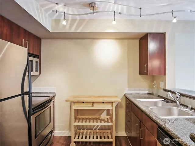 a bathroom with a granite countertop sink a mirror and shower