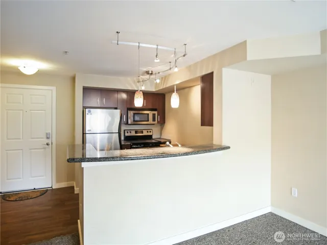 a kitchen with kitchen island a counter top space and stainless steel appliances