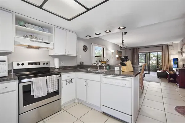 a kitchen with stainless steel appliances granite countertop a stove and white cabinets