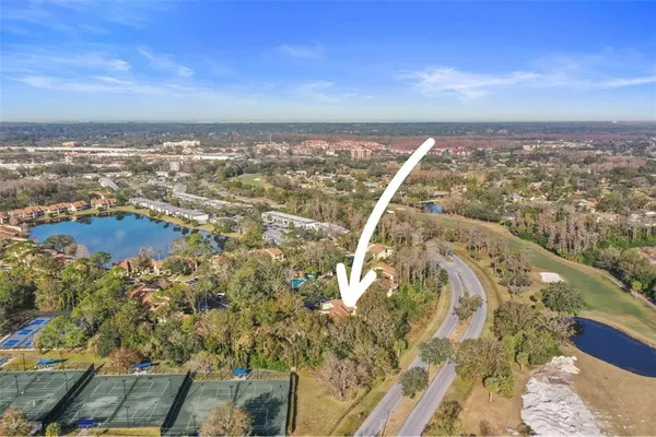 an aerial view of residential houses with outdoor space and trees