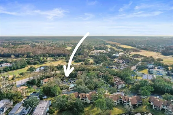 an aerial view of a residential houses with outdoor space and trees