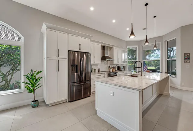 a large kitchen with stainless steel appliances kitchen island granite top and a view of living room