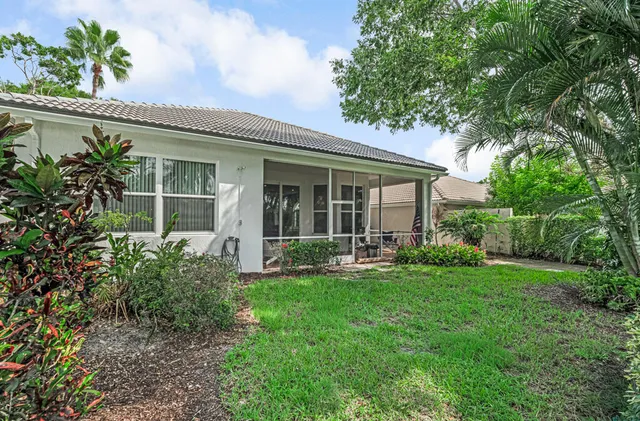 a view of a brick house with a big yard and large trees