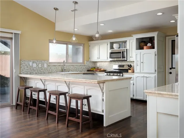 a kitchen with a table chairs refrigerator and microwave