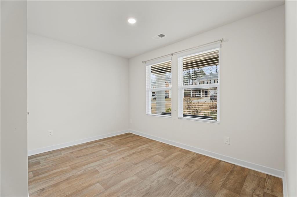 1149 Bluecoat Circle Hampton, GA 30228 - Photo 15 of 21 an empty room with wooden floor and windows