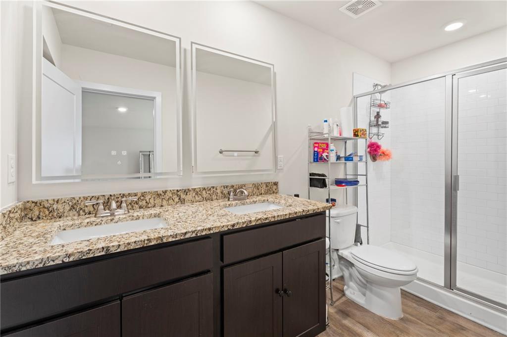 1149 Bluecoat Circle Hampton, GA 30228 - Photo 16 of 21 a bathroom with a granite countertop sink a toilet and a mirror