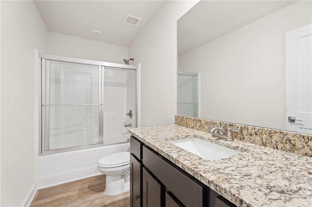 1149 Bluecoat Circle Hampton, GA 30228 - Photo 17 of 21 a bathroom with a granite countertop sink a toilet and shower
