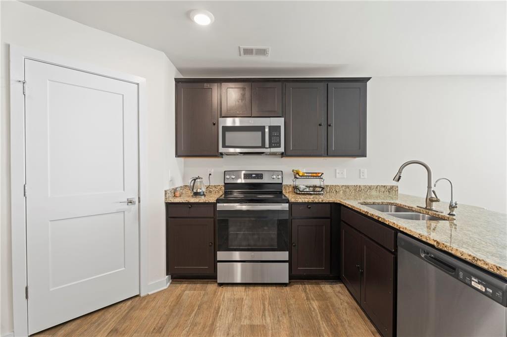 1149 Bluecoat Circle Hampton, GA 30228 - Photo 5 of 21 a kitchen with stainless steel appliances granite countertop a stove and a refrigerator