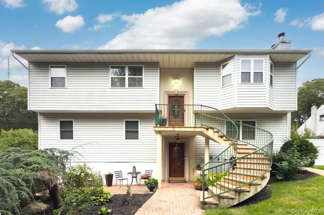a front view of a house with a garden and plants