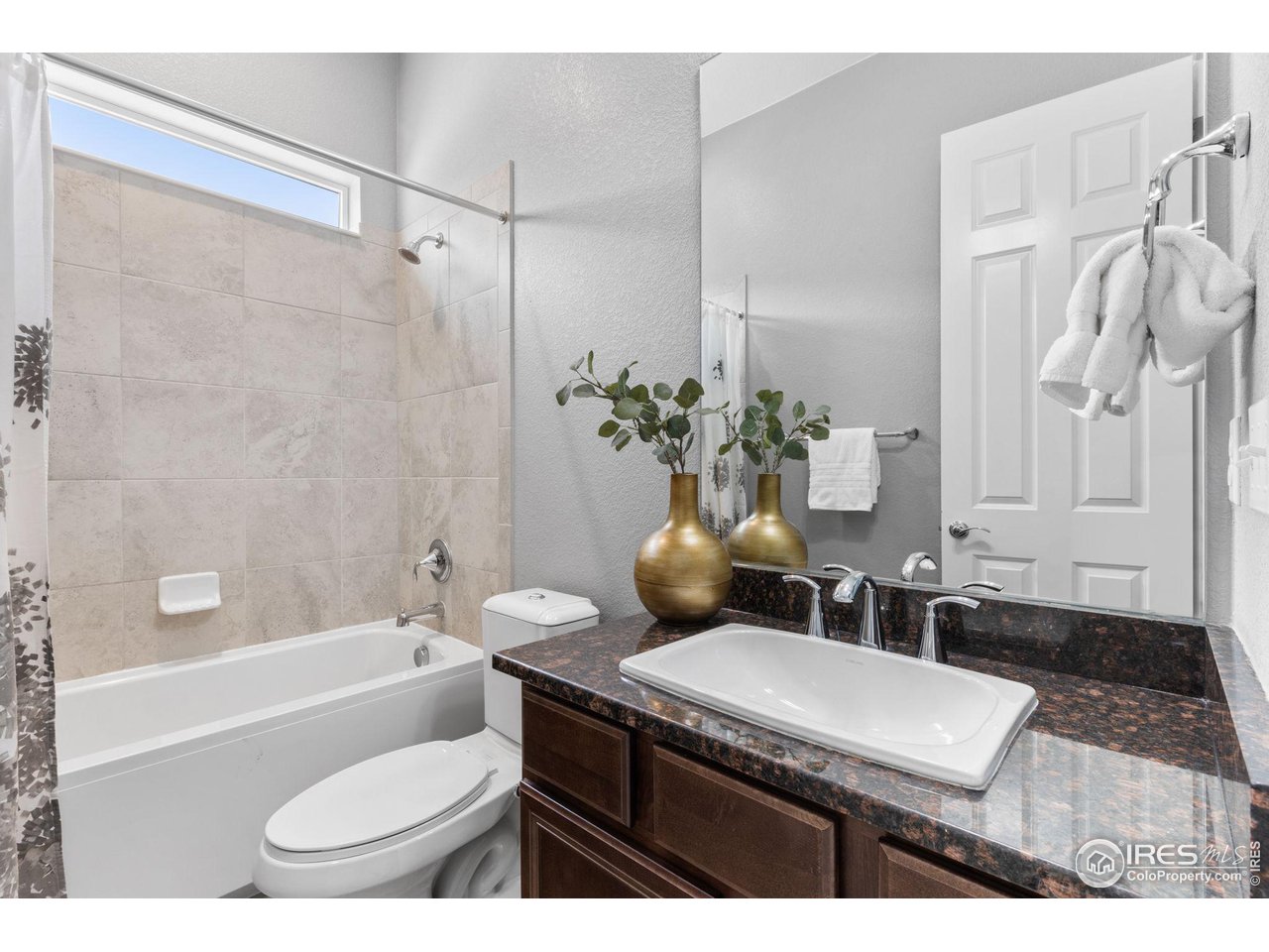 973 Stagecoach Drive Lafayette, CO 80026 - Photo 17 of 39 a bathroom with a granite countertop sink toilet a mirror and a bathtub