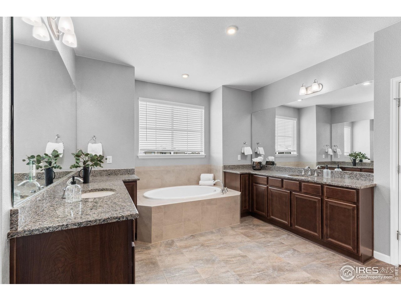 973 Stagecoach Drive Lafayette, CO 80026 - Photo 20 of 39 a bathroom with a granite countertop tub a double vanity sink a window and a mirror