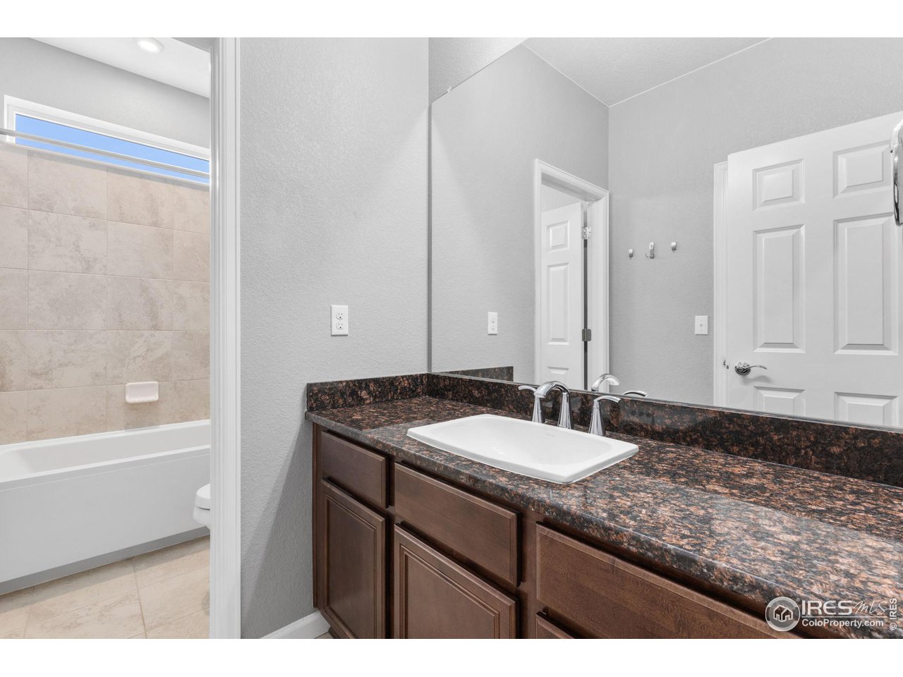 973 Stagecoach Drive Lafayette, CO 80026 - Photo 23 of 39 a bathroom with a granite countertop sink a mirror and a bathtub