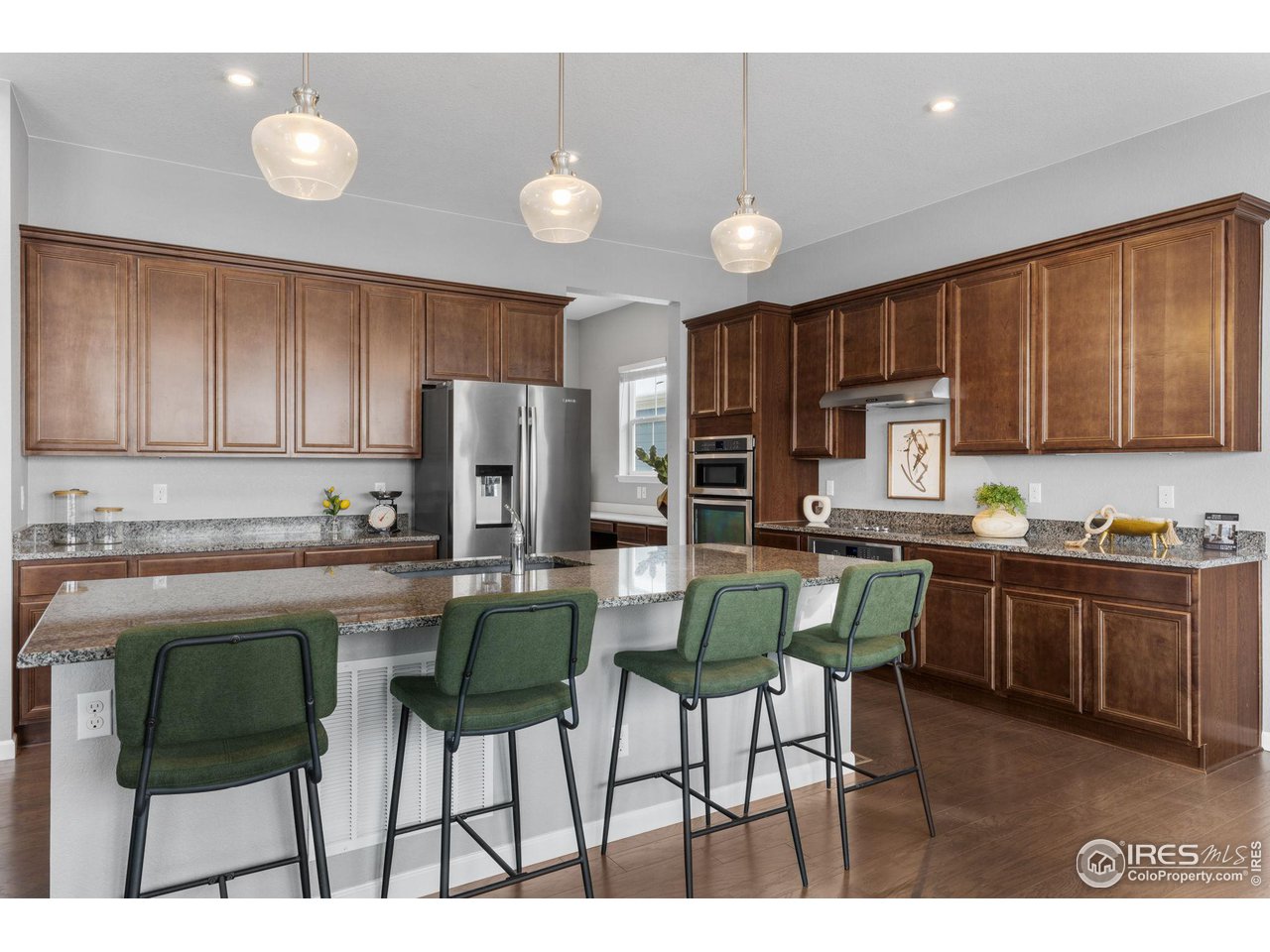 973 Stagecoach Drive Lafayette, CO 80026 - Photo 6 of 39 a kitchen with stainless steel appliances kitchen island granite countertop a table chairs sink and cabinets