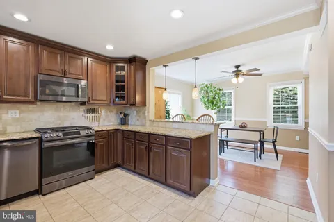 a kitchen with stainless steel appliances granite countertop a stove a sink and a microwave