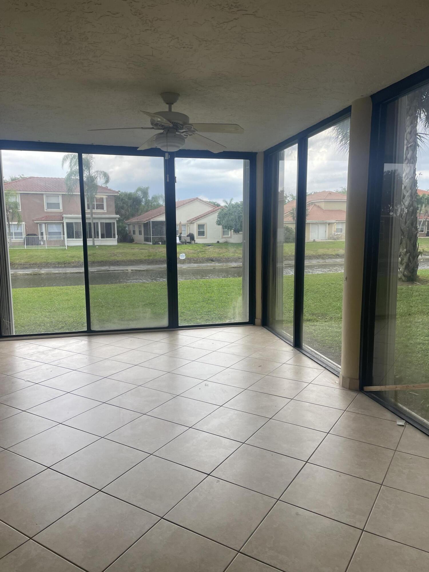 18258 Covina Way, Unit 102 Boca Raton, FL 33498 - Photo 14 of 14 an empty room with floor to ceiling windows and an outdoor view