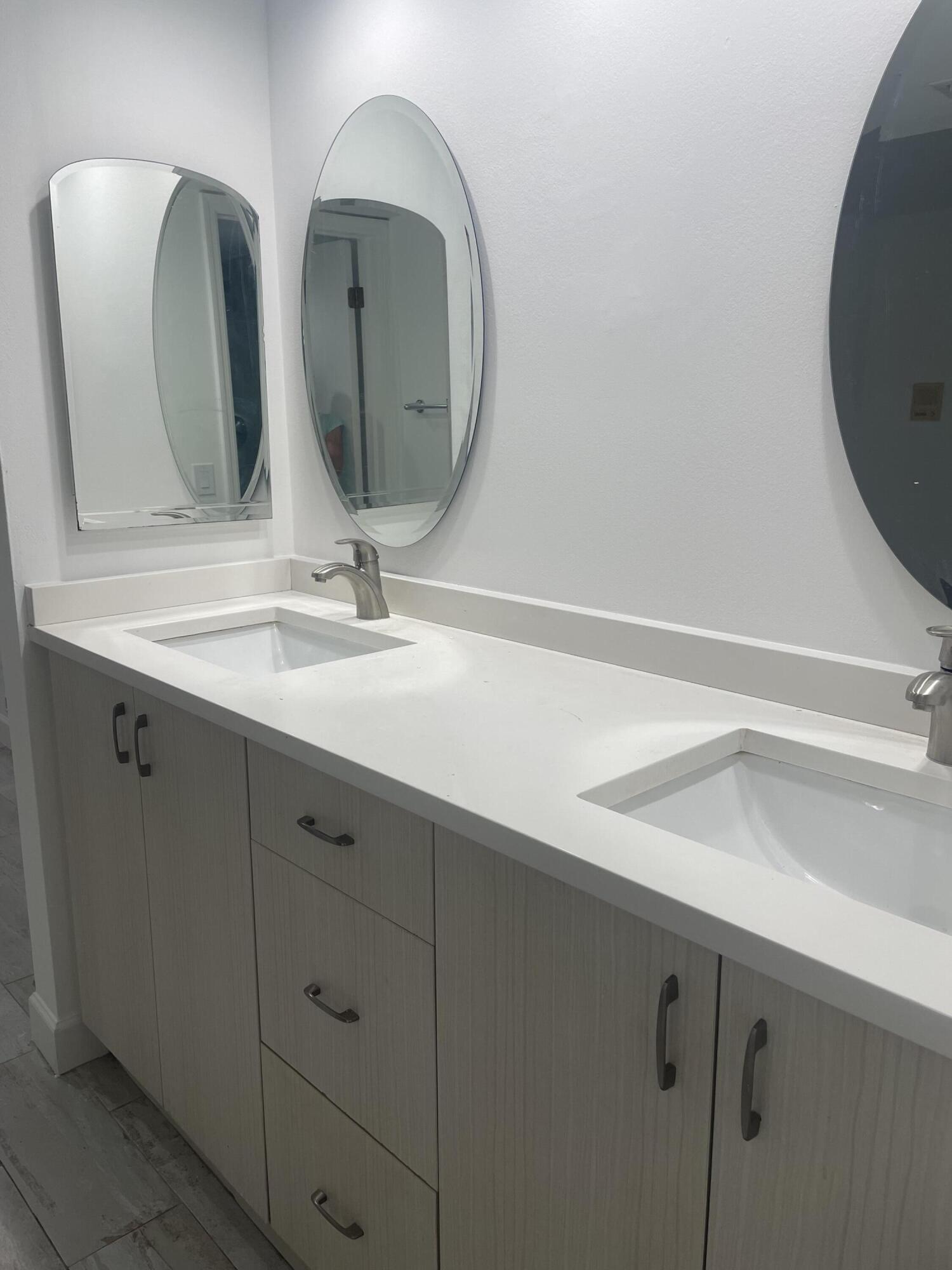 18258 Covina Way, Unit 102 Boca Raton, FL 33498 - Photo 7 of 14 a bathroom with double vanity sink and a mirror