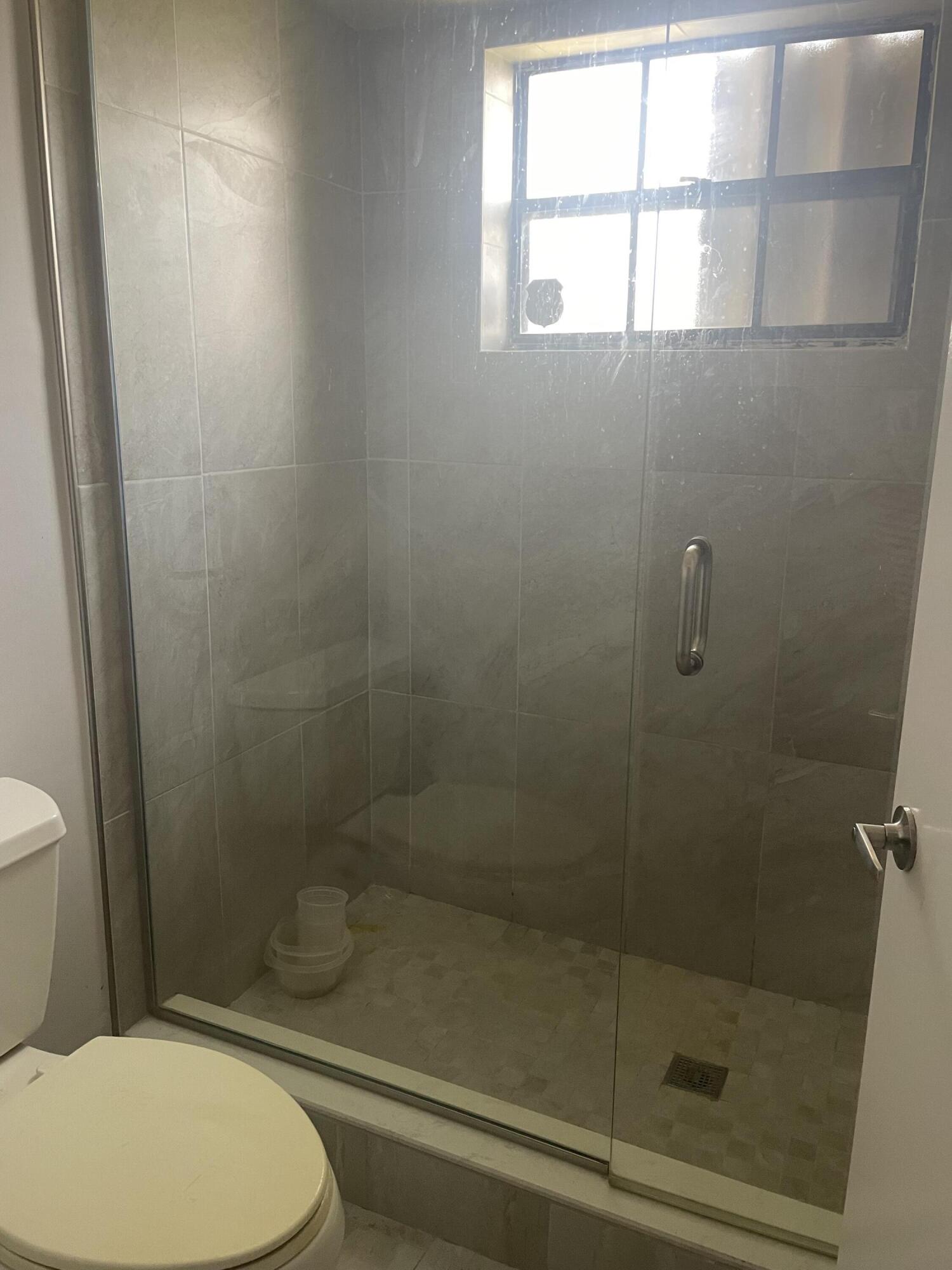 18258 Covina Way, Unit 102 Boca Raton, FL 33498 - Photo 9 of 14 a bathroom with a toilet and a shower