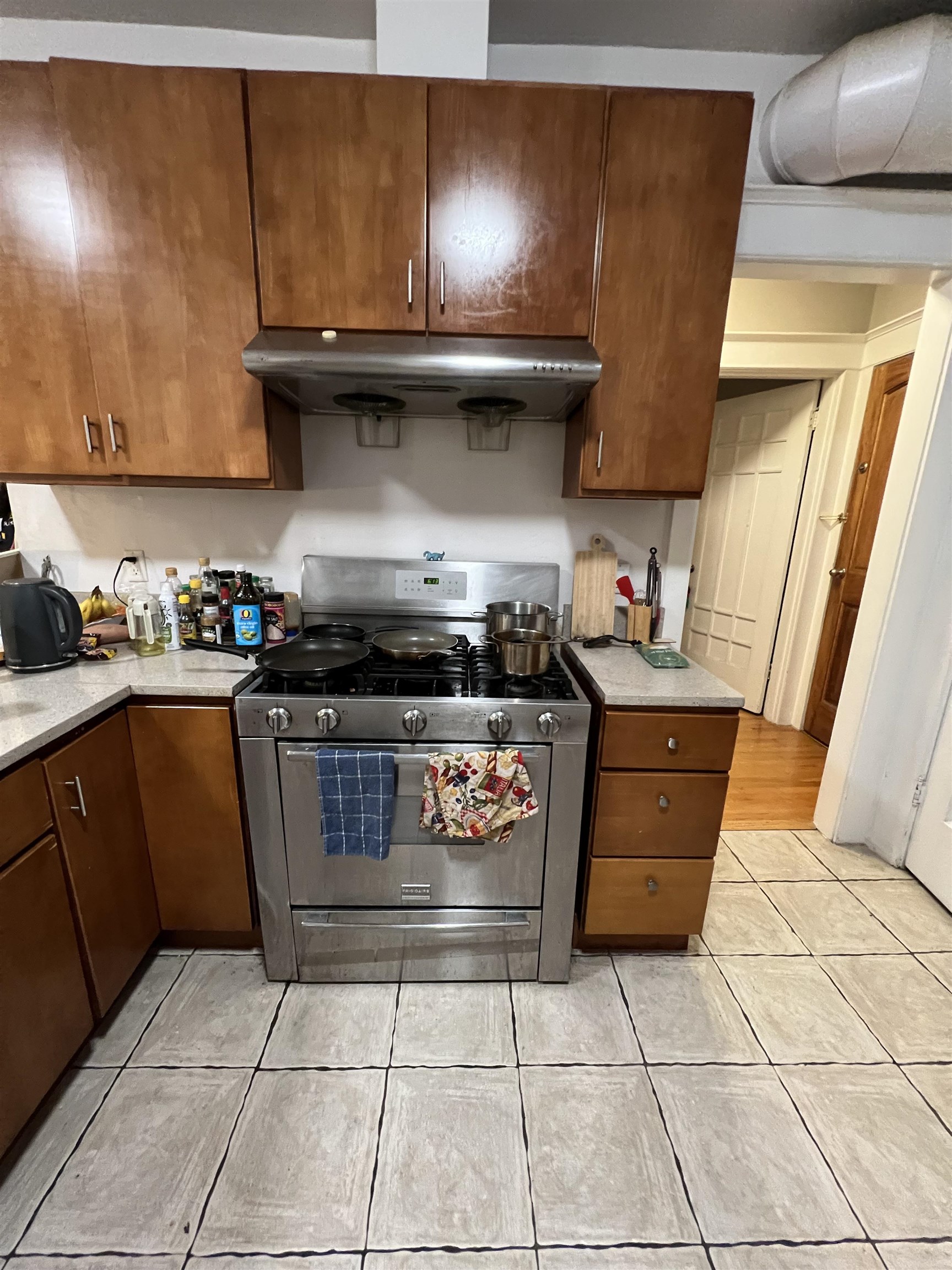 2214 Durant Avenue, Unit 5 Berkeley, CA 94704 - Photo 2 of 8 Kitchen with stainless steel gas stove, wood finish cabinetry, light tile patterned floors, and light stone countertops