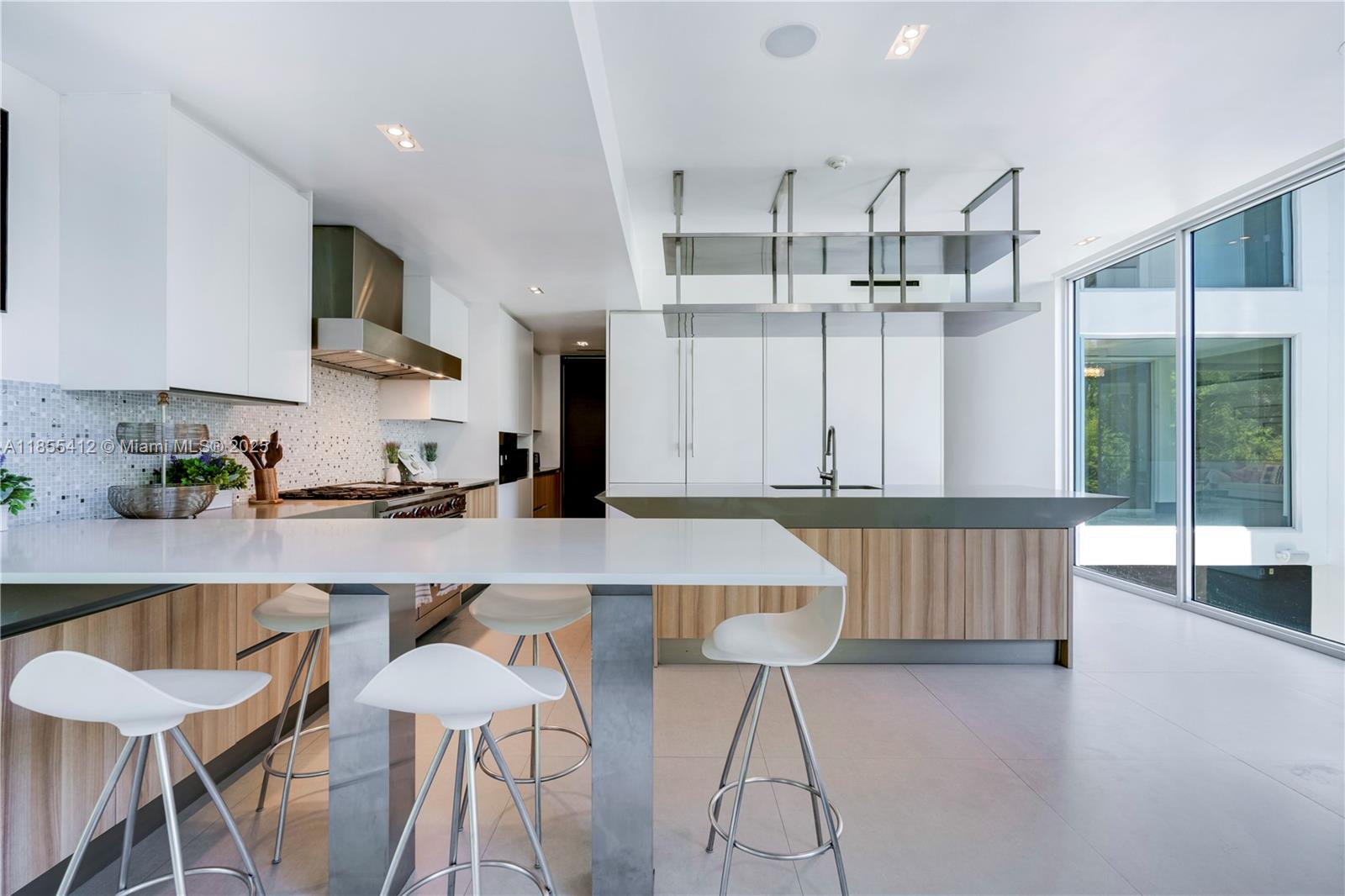 545 Sabal Palm Drive Key Biscayne, FL 33149 - Photo 32 of 100 a kitchen with stainless steel appliances a table and chairs in it