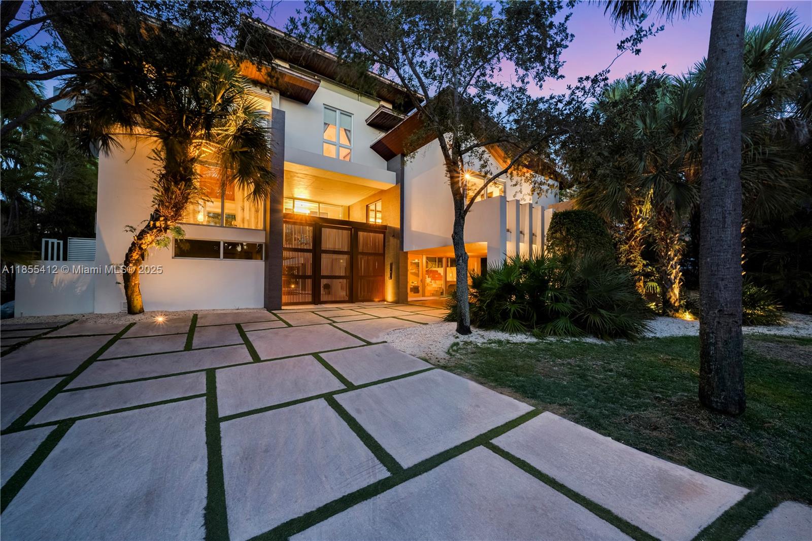 545 Sabal Palm Drive Key Biscayne, FL 33149 - Photo 4 of 100 a view of a patio with couches and table and chairs under an umbrella with a tree