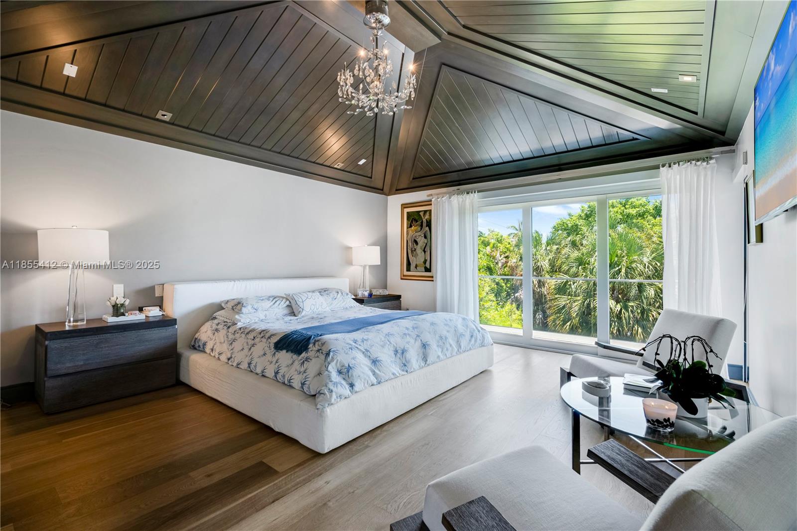 545 Sabal Palm Drive Key Biscayne, FL 33149 - Photo 57 of 100 a bedroom with a large bed and a chandelier