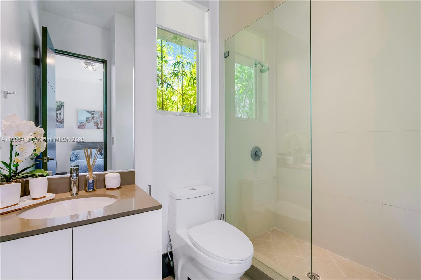 545 Sabal Palm Drive Key Biscayne, FL 33149 - Photo 83 of 100 a bathroom with a granite countertop sink a toilet a mirror and shower