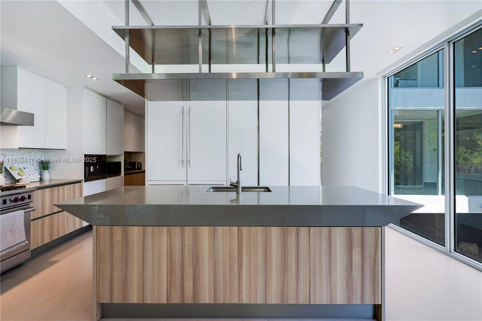 545 Sabal Palm Drive Key Biscayne, FL 33149 - Photo 92 of 100 a kitchen with stainless steel appliances granite countertop a stove a sink and a granite counter tops with white cabinets