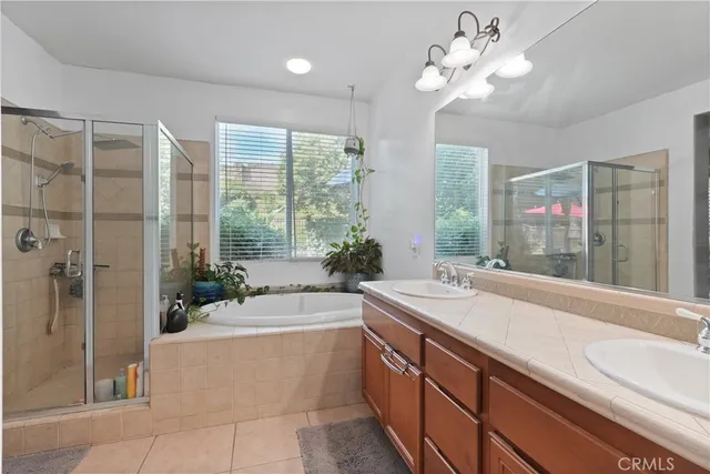a spacious bathroom with a granite countertop sink a large mirror and a bathtub