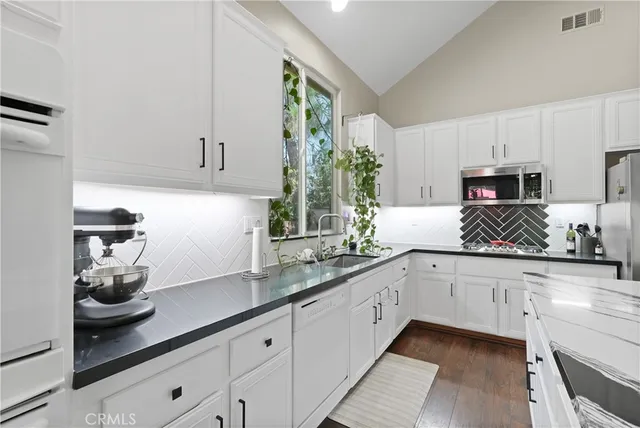 a kitchen with granite countertop white cabinets and white appliances