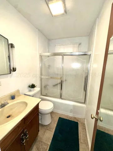 a bathroom with a toilet mirror vanity and sink