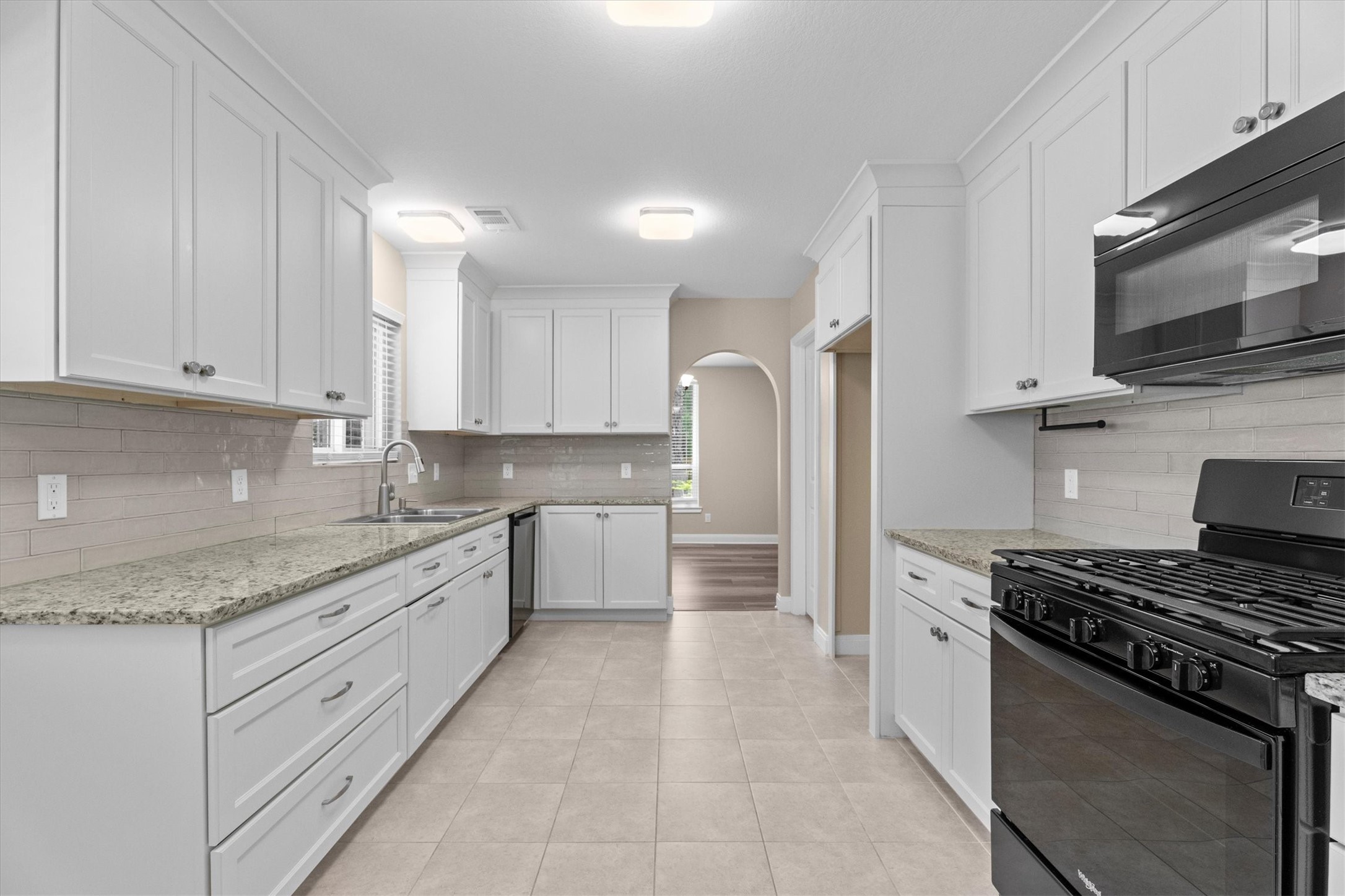 6530 Bayonne Drive Spring, TX 77389 - Photo 17 of 37 a kitchen with stainless steel appliances granite countertop a stove a sink and a microwave