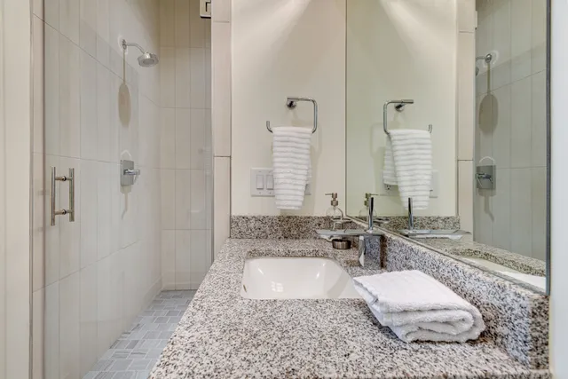 a large bathroom with a granite countertop tub sink and mirror