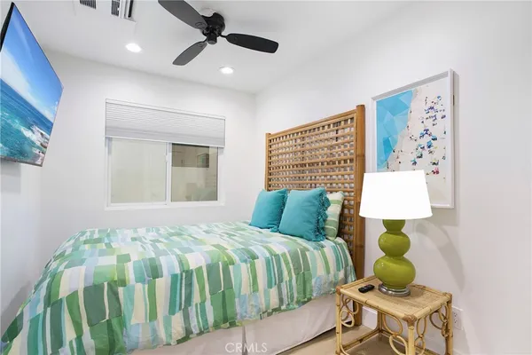 a bedroom with a bed mirror and a window