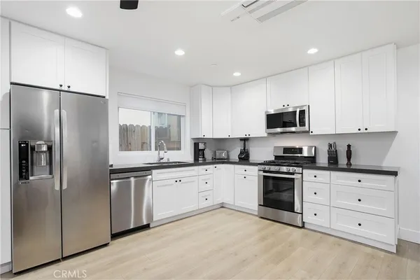 a kitchen with stainless steel appliances granite countertop a stove a sink and a refrigerator