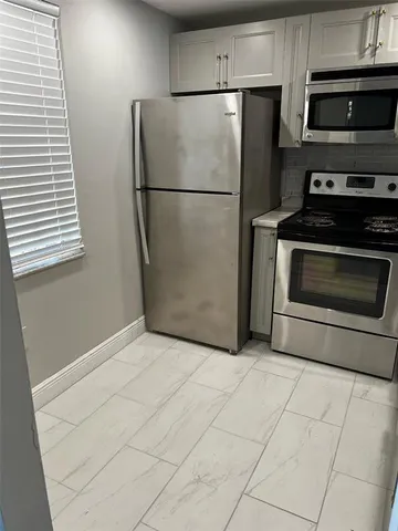 a kitchen with cabinets and stainless steel appliances