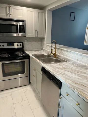 a kitchen with granite countertop a stove and a sink
