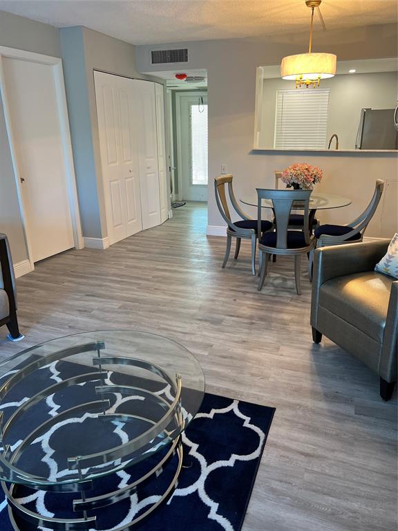 9070 Lime Bay Boulevard, Unit 209 Tamarac, FL 33321 - Photo 3 of 27 a room with wooden floor and furniture